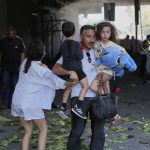 Njerëzit reagojnë pasi një raketë nga Irani godet në Haifa, Izrael, të premten. (Baz Ratner / AP)